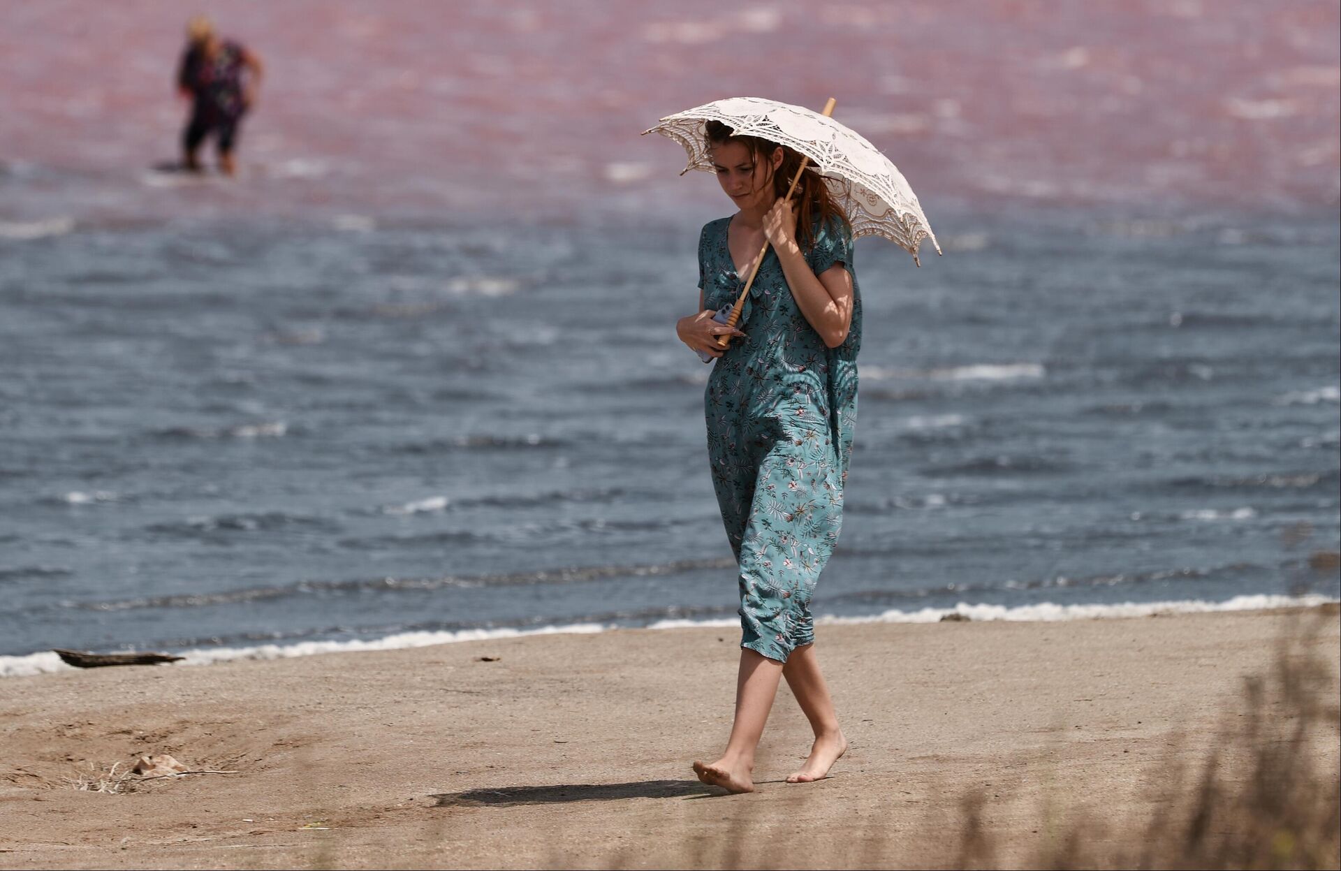 Девушка идет под зонтом по берегу озера Сасык-Сиваш под Евпаторией - РИА Новости, 1920, 06.07.2022